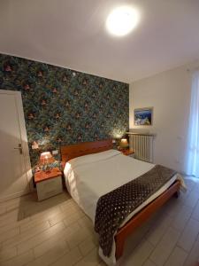 a bedroom with a large bed with a floral wallpaper at Il Nido del Cigno in Sirmione