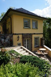 una casa gialla con un tavolo e sedie di fronte di Hanghaus der Villa Oderblick a Oderberg