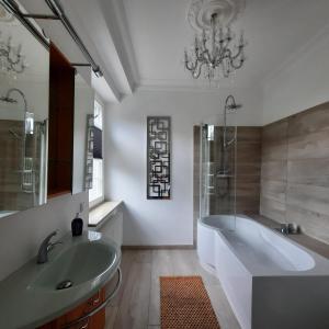 un bagno con vasca, lavandino e specchio di Hanghaus der Villa Oderblick a Oderberg