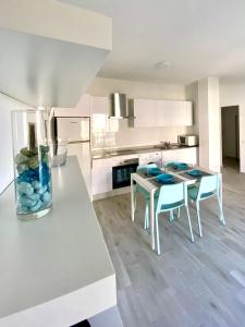 a kitchen with white cabinets and a table and chairs at Apartamento MEDAL in El Cotillo