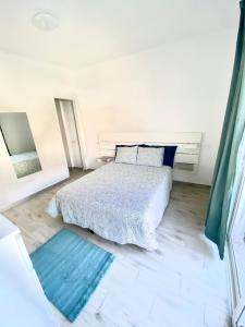 biała sypialnia z łóżkiem i lustrem w obiekcie Apartamento MEDAL w mieście Cotillo