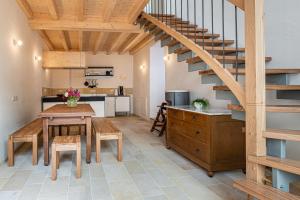 a kitchen and dining room with a wooden staircase at Nengshof Ferienhaus Glockenblume in Wißmannsdorf