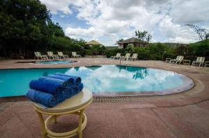 una piscina con toallas azules sobre una mesa y sillas en Sentrim Mara Lodge en Ololaimutiek