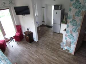 a living room with a hard wood floor and a refrigerator at Domek przy Puszczy Białowieskiej in Dubiny +9 photos