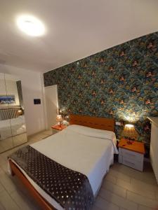 a bedroom with a large bed with a floral wallpaper at Il Nido del Cigno in Sirmione