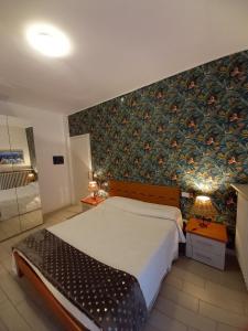 シルミオーネにあるIl Nido del Cignoの花柄の壁紙を用いたベッドルーム1室(大型ベッド1台付)