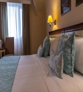 Una cama o camas en una habitación de Alto Calafate Hotel