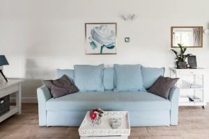 een blauwe bank in een woonkamer met een tafel bij Woubrugge Logies in Woubrugge