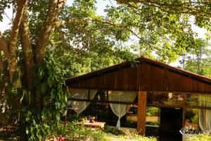 a house in a garden with a tree at Pousada e Restaurante Victórios in Caeté