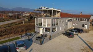 a house with cars parked in a parking lot at Prenoćište Binta in Vranje