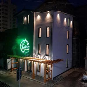 a building with a neon sign on the side of it at LIANE BOUTIQUE HOTEL in Câmpulung Moldovenesc
