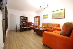 チクラナ・デ・ラ・フロンテーラにあるOasis en la playaのリビングルーム(オレンジ色のソファ、テーブル付)