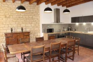 a kitchen with a large wooden table and chairs at Château des Loups - Les Cèdres Bleus in Échiré