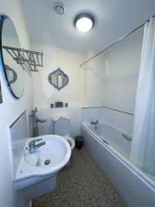 a bathroom with a sink and a toilet and a tub at Station Side Penthouse in Wolverhampton