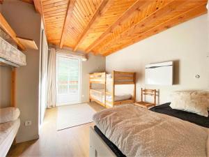 a bedroom with a large bed and a wooden ceiling at Le Carot : gîte de montagne indépendant et calme in Campan