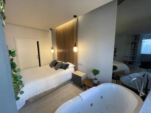 a bedroom with a bed and a bath tub at MiluiSuites Loft and Spa Catedral. in Santander