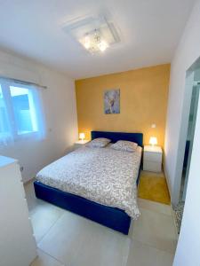 ein Schlafzimmer mit einem blauen Bett und zwei Lampen in der Unterkunft Appartement la plage de la pointe rouge in Marseille