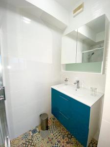 ein Badezimmer mit einem blauen Waschbecken und einem Spiegel in der Unterkunft Appartement la plage de la pointe rouge in Marseille