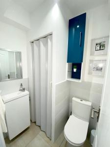 ein Badezimmer mit einer weißen Toilette und einem blauen Schrank in der Unterkunft Appartement la plage de la pointe rouge in Marseille