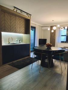 a kitchen and dining room with a table and a sink at Apartament Złoty F4 Teren Ośrodka SunSnow Białka Tatrzańska in Białka Tatrzańska