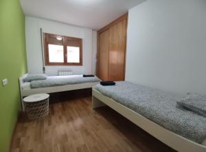 a bedroom with two beds and a window at Apartamento Miral21 in Jaca