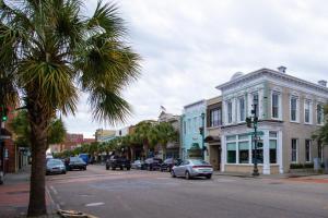 a city street with a palm tree and cars on the road at Contemporary Home in Perfect Location - 207 B St Philip Street in Charleston