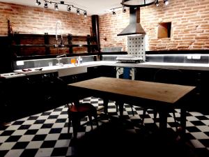 a kitchen with a wooden table and a checkered floor at la fermette des grains dorés in Lafrançaise