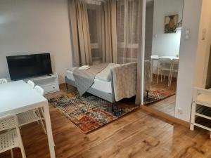 Sala de estar con cama y espejo en Apartament Młynarska - indywidualny dostęp, en Piaseczno