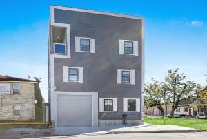 a large gray building with a white garage door at Stunning Condos Near French Quarter in New Orleans