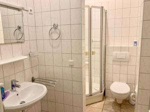 a bathroom with a toilet and a sink and a shower at Haus Anastasia in Warnemünde +7 photos