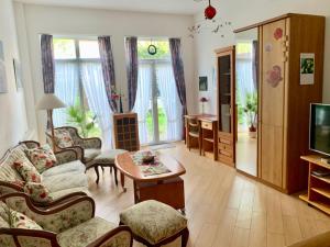a living room with a couch and chairs and a tv at Haus Anastasia in Warnemünde