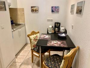 a kitchen with a table and two chairs and a counter at Haus Anastasia in Warnemünde