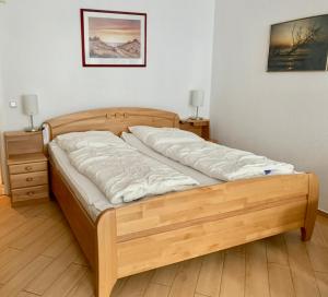 a wooden bed in a room with two night stands at Haus Anastasia in Warnemünde
