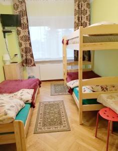 a room with two bunk beds and a window at Tanie Noclegi Mieszkanka in Żyrardów