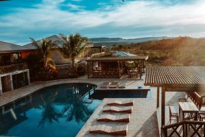 a swimming pool with chairs and a house at Villa Annapurna in Alto Paraíso de Goiás