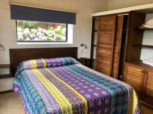 a bedroom with a bed and a window with flowers at Las Pakas in La Paloma