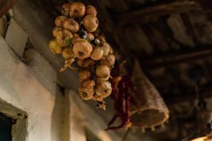 Een hoop uien aan een plafond. bij Etno House Shancheva in Kratovo