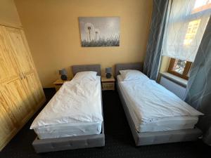 two twin beds in a room with a window at FeWo Nietleben in Halle an der Saale