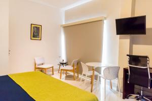 a hotel room with a bed and a flat screen tv at Hotel Agualcas in Managua