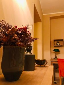 dos jarrones negros con flores en una mesa de madera en VNVP Amber, en Štip