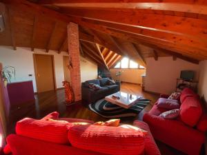 a living room with red couches and a table at Villa Dina in Olgiate Olona