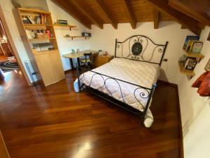 een slaapkamer met een bed en een houten vloer bij Villa Dina in Olgiate Olona
