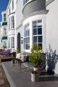 a porch with a bench and potted plants on a house at The View on the terrace in Weymouth