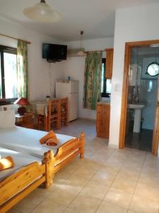 a bedroom with a bed and a kitchen with a table at Mabella Beach in Plati