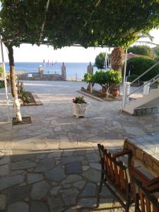 a stone patio with a bench and a view of the ocean at Mabella Beach in Plati