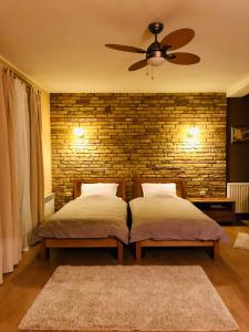 two beds in a bedroom with a brick wall at VNVP Amber in Štip