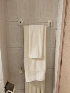 uma casa de banho com 2 toalhas brancas num chuveiro em Vivienda Vacacional El Majo em Siero