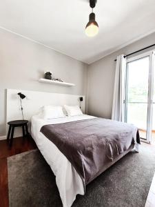 biała sypialnia z dużym łóżkiem i oknem w obiekcie Santa Luzia's Pearl V - Two Bed Apartment w Funchal