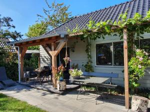 a wooden pergola on a patio with a table at Woubrugge Logies in Woubrugge