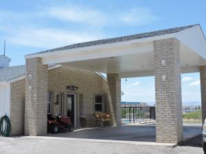 a large brick garage with a white roof at Riata Inn - Presidio in Presidio